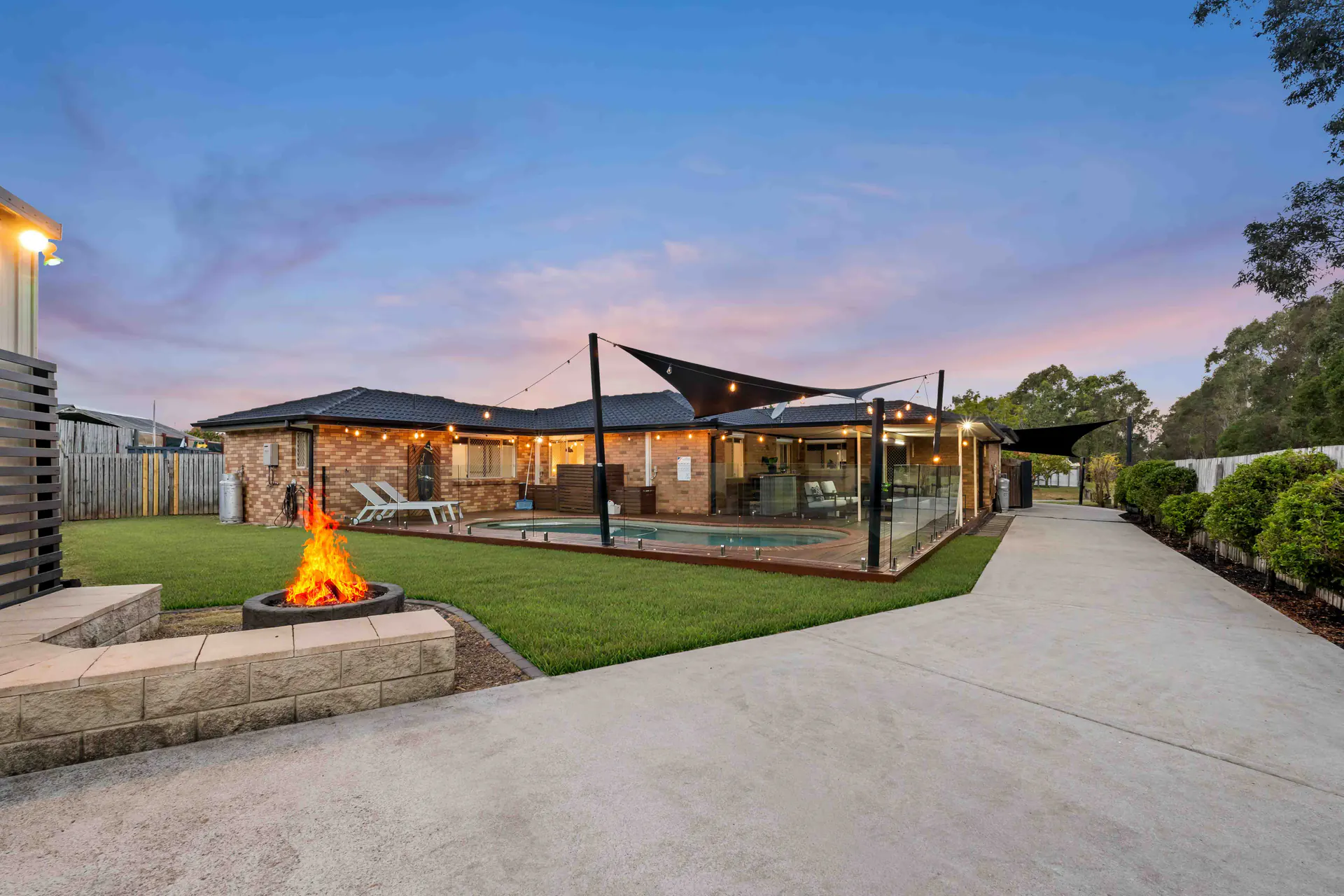 Twilight photography of a home with a pool and fire pit