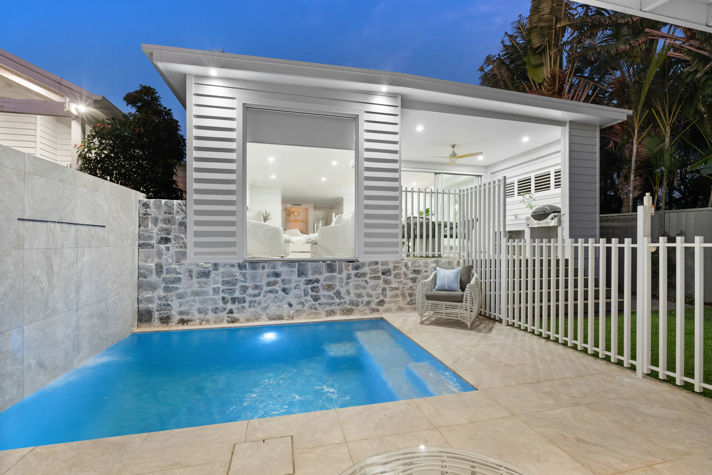 Twilight view of a modern Margate home and pool