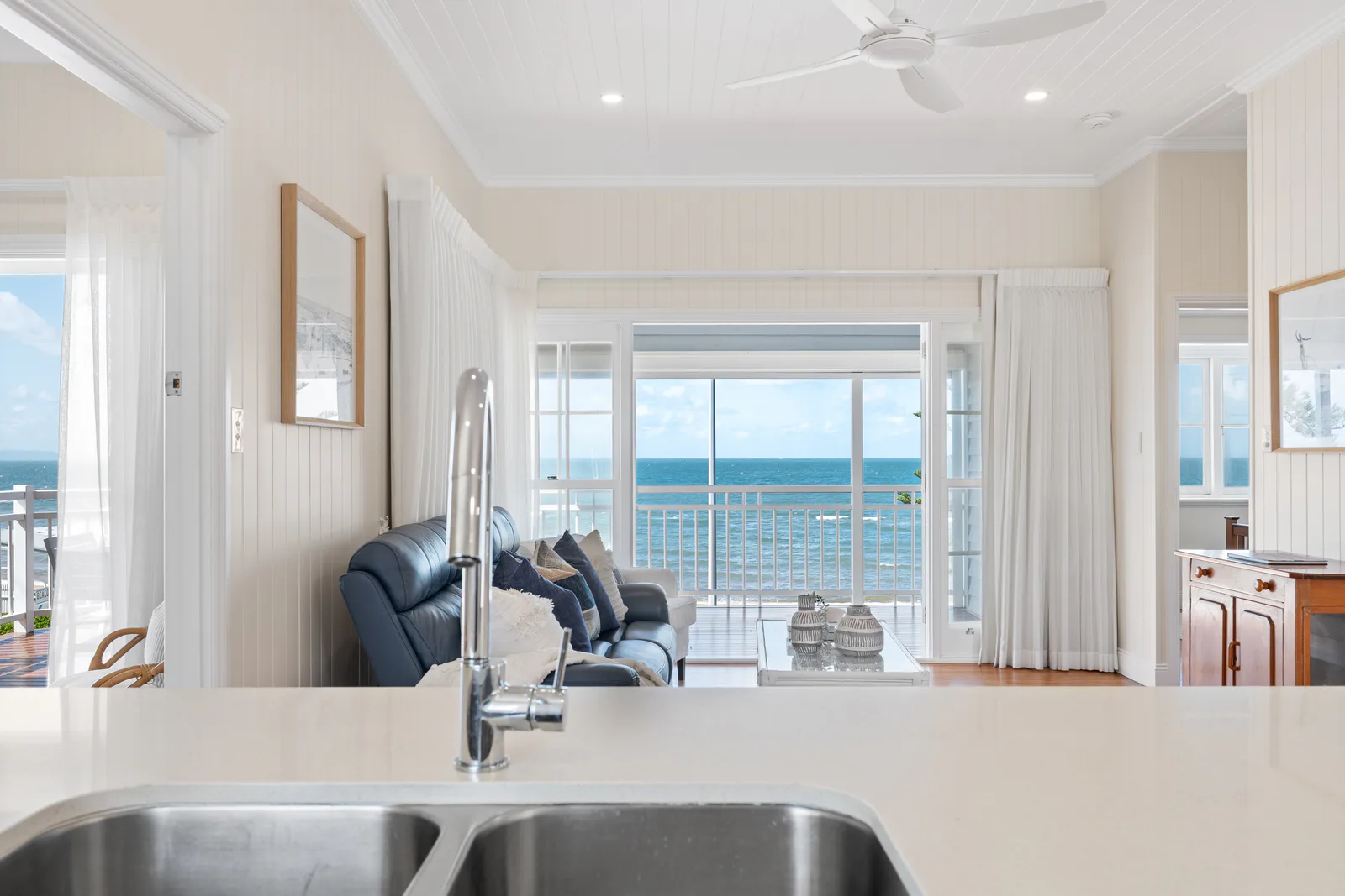 Bright coastal living room opening to an ocean view