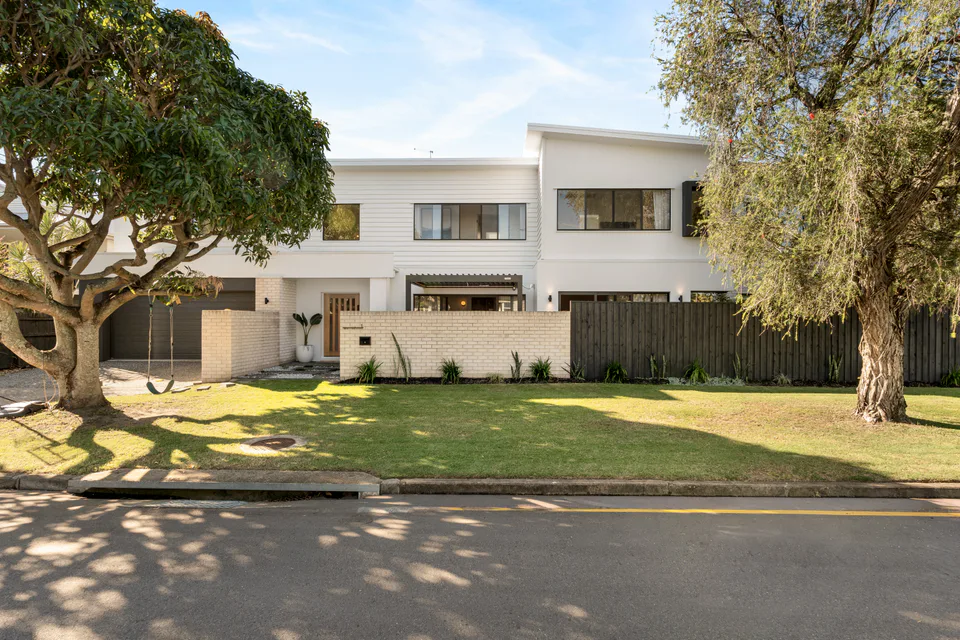 Contemporary family home framed by mature trees