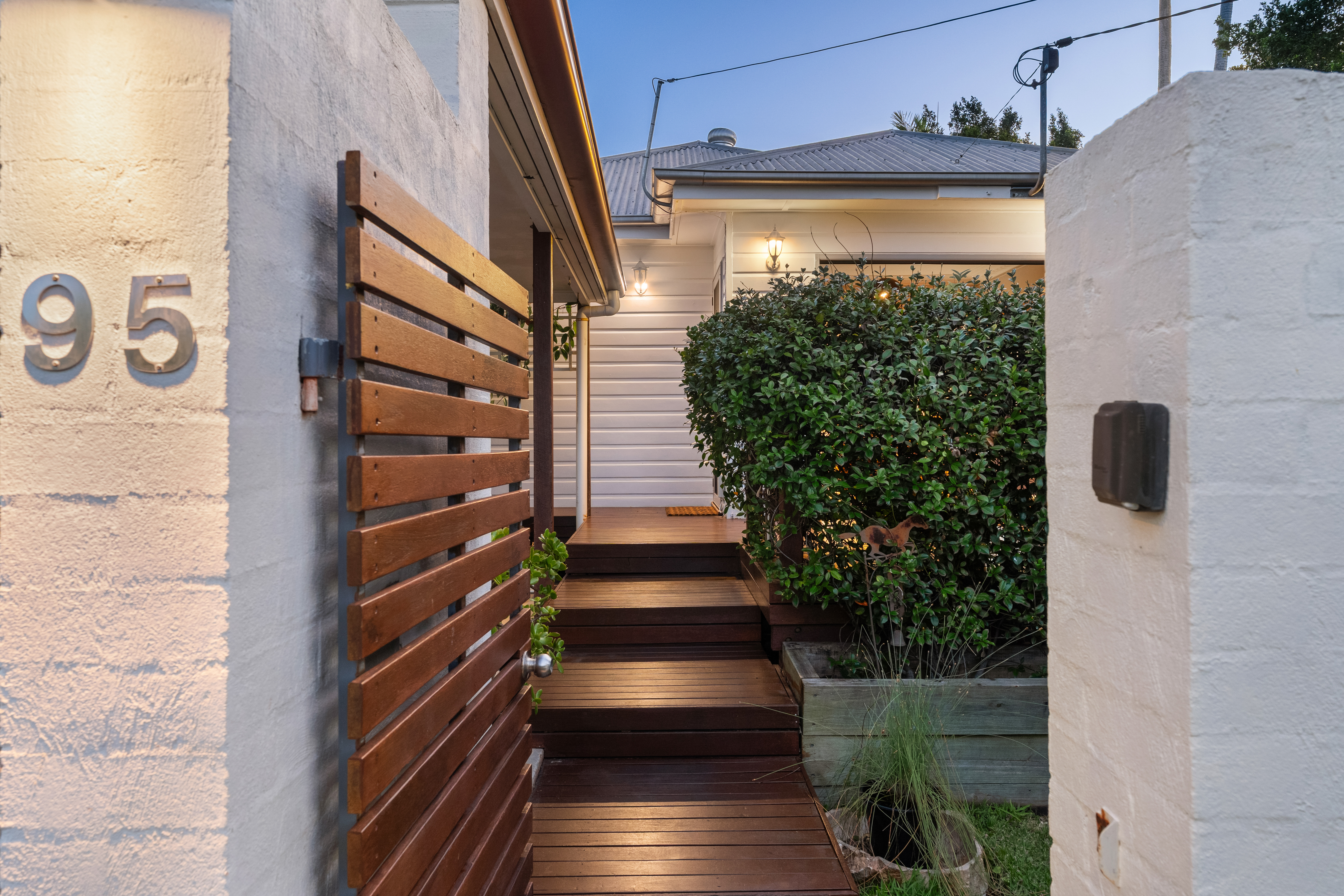 Timber entry gate and garden path at dusk