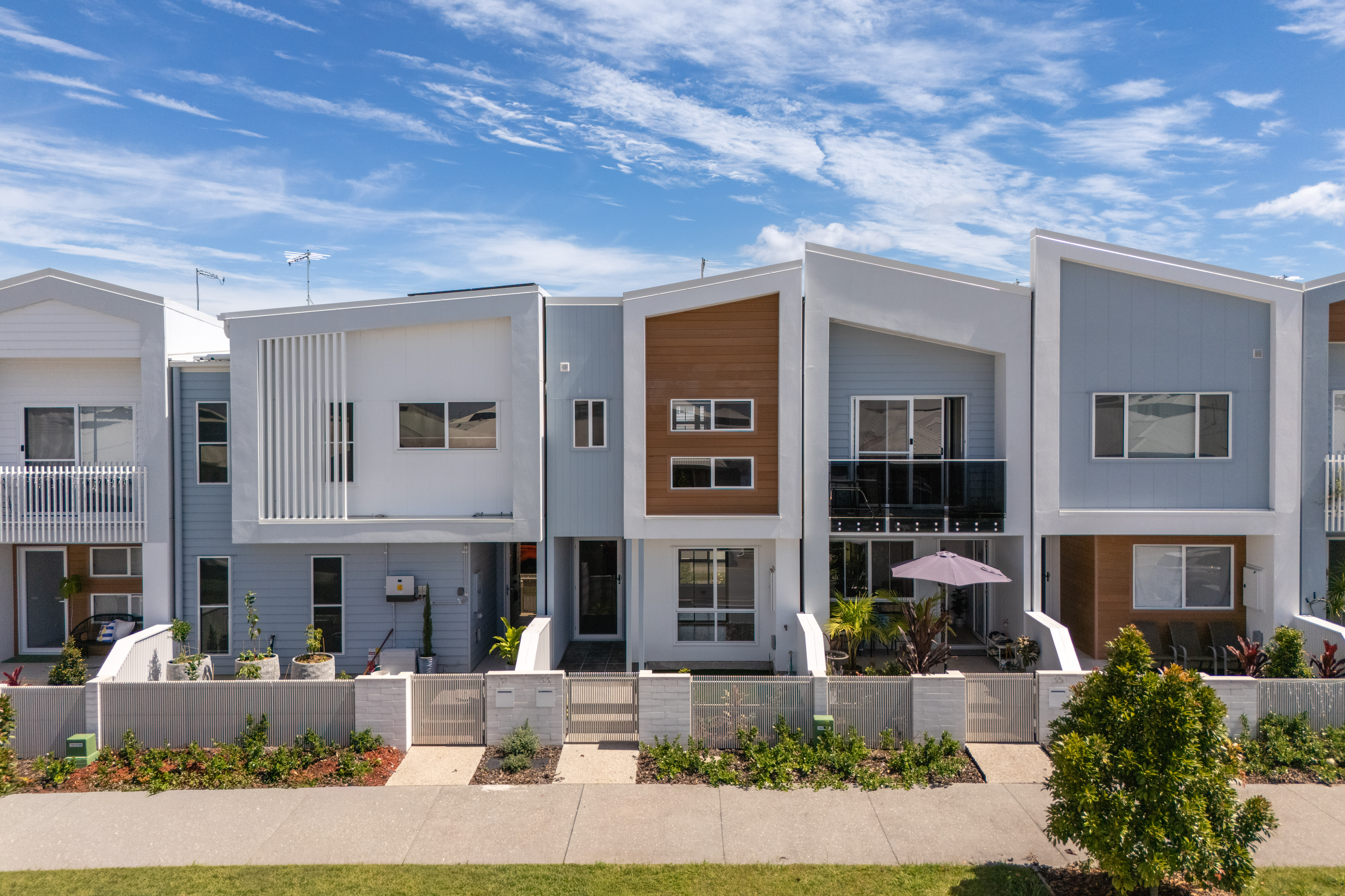 Contemporary townhouse row under a wide blue sky